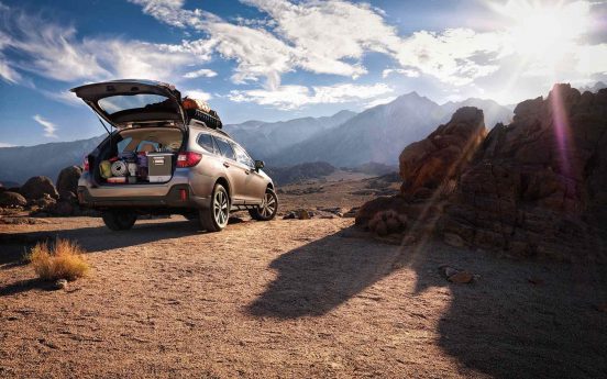 Image of a 2019 Subaru Outback with the trunk open in a desert landscape.