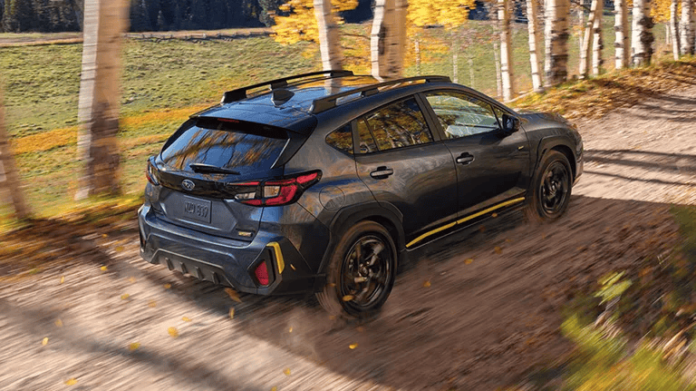2027 Subaru Crosstrek driving down a gravel road